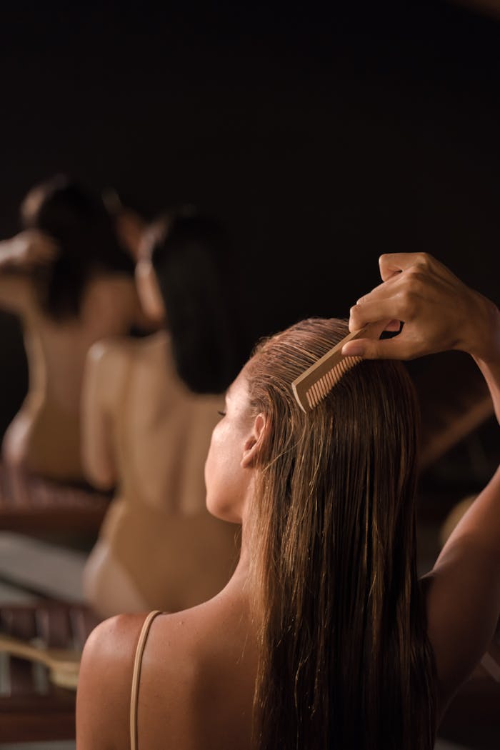 Back view of women grooming hair with combs in a serene spa setting, promoting self-care.